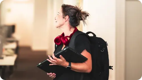 Medewerker klantencontact bij N-Allo met laptop en headset in kantooromgeving.